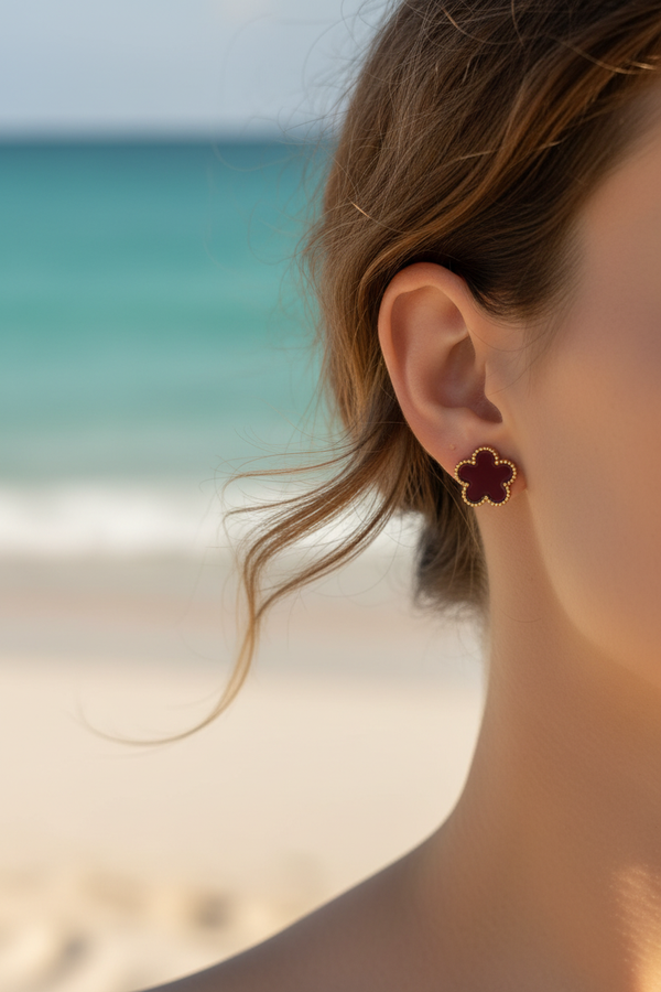 Boucles d'oreilles – Puces trèfle bordeaux/prune & contour billes dorées – lifestyle plage