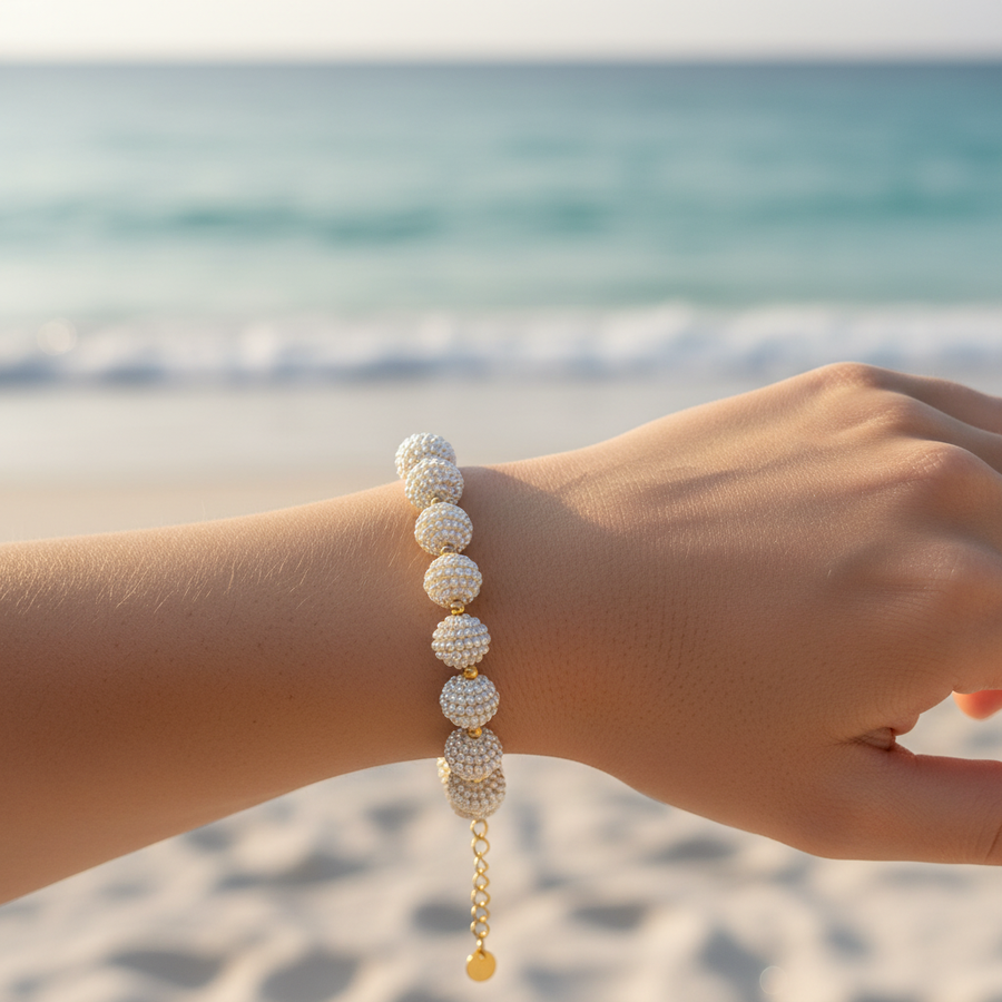 Bracelet boules sphères recouvertes micro-perles blanches connecteurs dorés – lifestyle plage