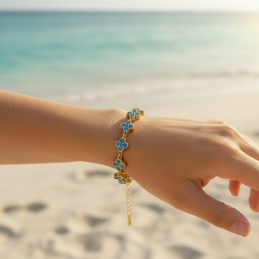 Bracelet chaîne dorée maillons trèfles pavé cristaux bleu pervenche – lifestyle plage