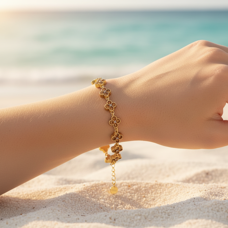 Bracelet chaîne dorée maillons trèfles pavé cristaux marron cognac topaze – lifestyle plage