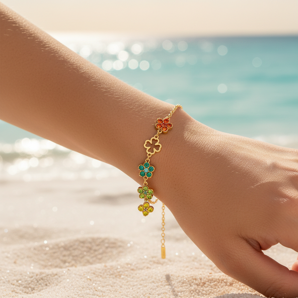 Bracelet chaîne fine dorée 5 charms fleurs multicolores & trèfles ajourés groupés – lifestyle plage