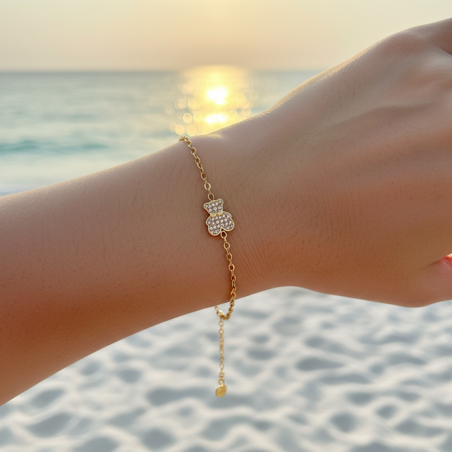 Bracelet chaîne fine dorée charm ourson pavé cristaux champagne – lifestyle plage