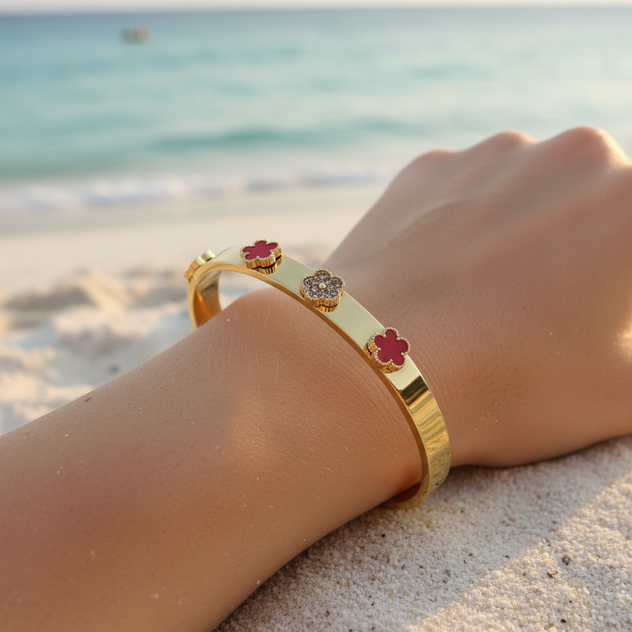 Bracelet jonc doré & petits trèfles rouge corail & pavé cristaux – lifestyle plage
