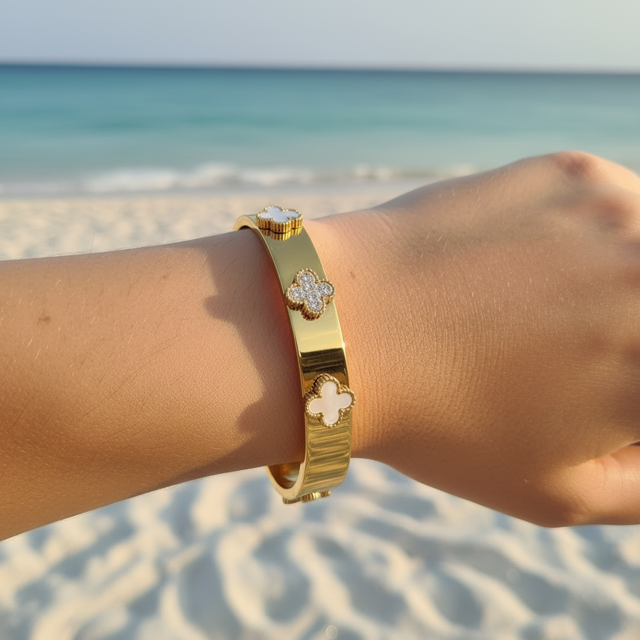 Bracelet jonc large doré & trèfles alternés nacre/pavé/nacre – lifestyle plage